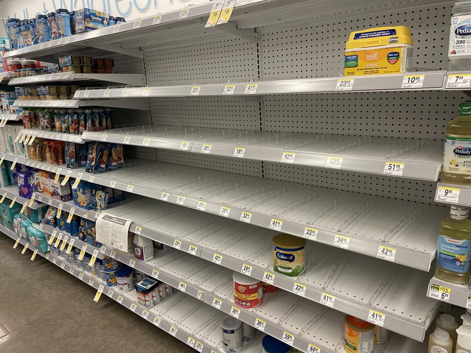 An empty supermarket shelf reflects a shortage of infant formula.
