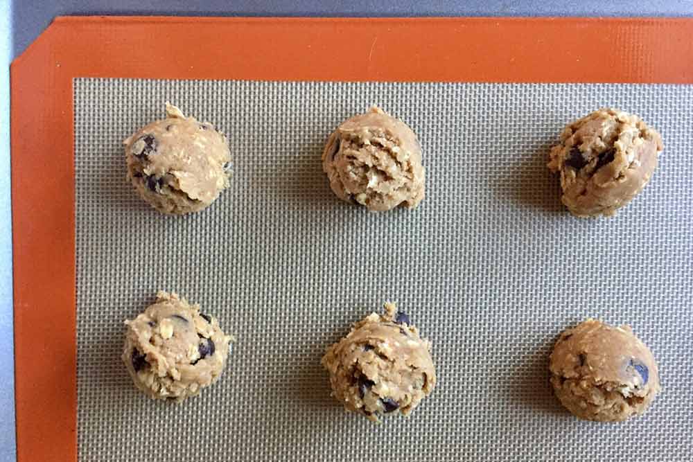 Scoops of cookie dough arranged on a baking sheet.