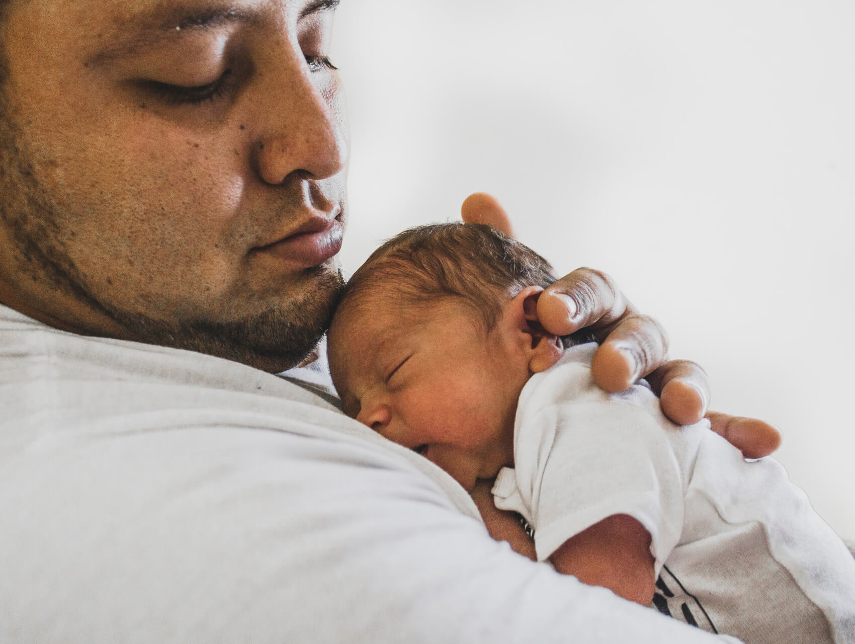 A newborn resting on a parent’s chest, showcasing a nurturing moment of bonding and care.