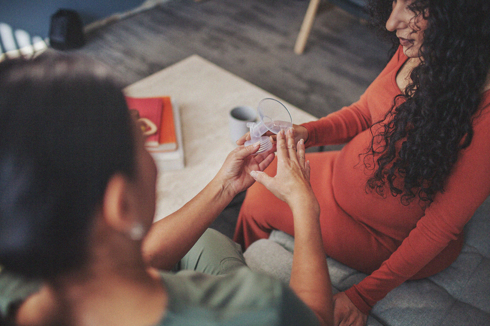 A close-up of a parent and an International Board Certified Lactation Consultant holding a breast pump.