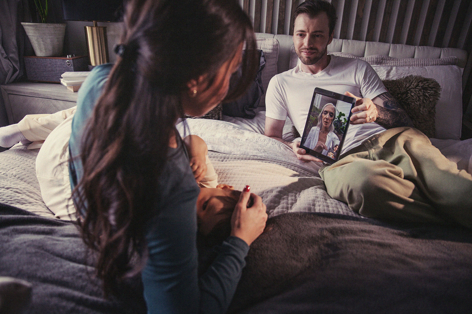 Parents on a video call with an International Board Certified Lactation Consultant while caring for their baby.