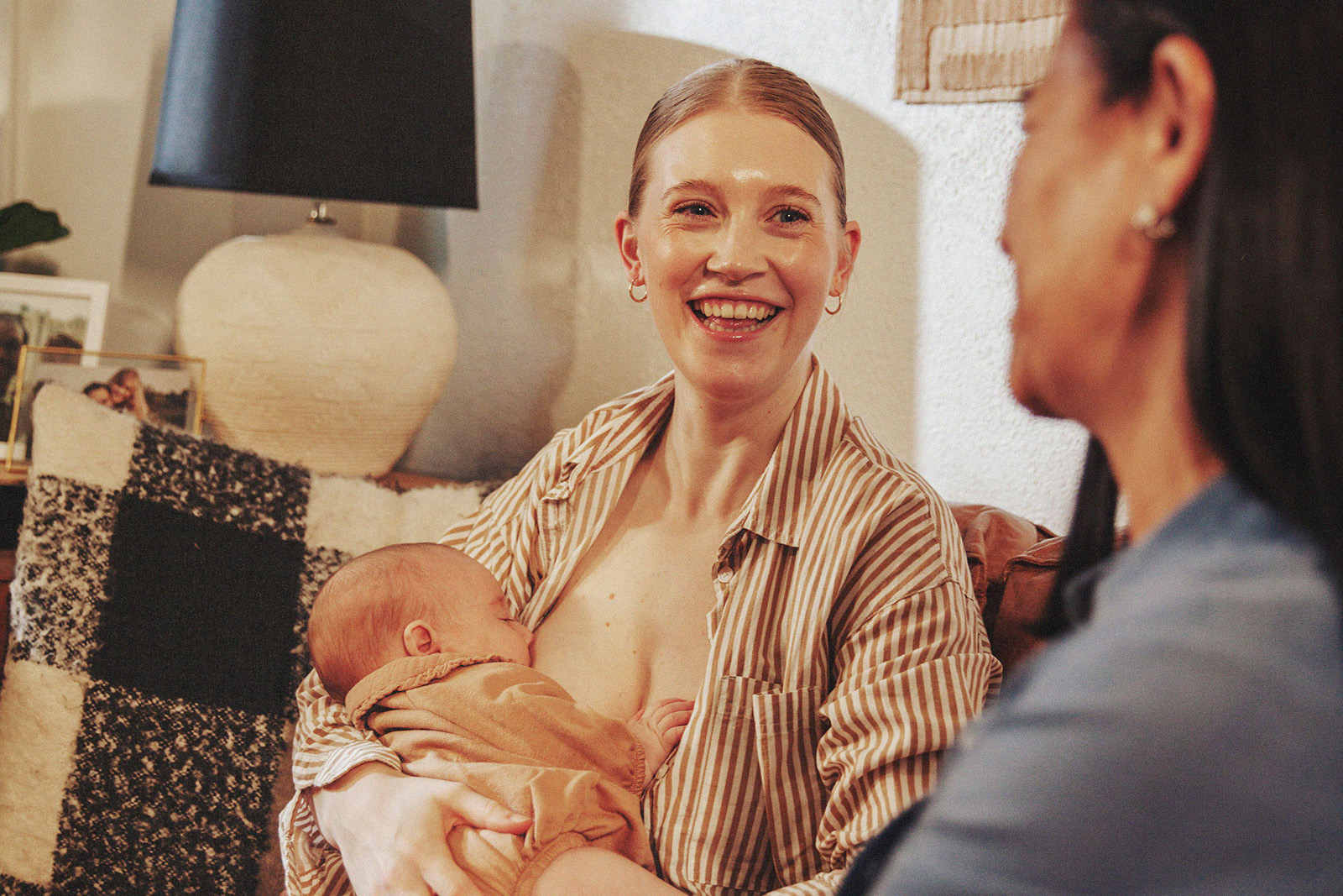 A parent smiling while breastfeeding, showcasing joy while connecting with International Board Certified Lactation Consultant.