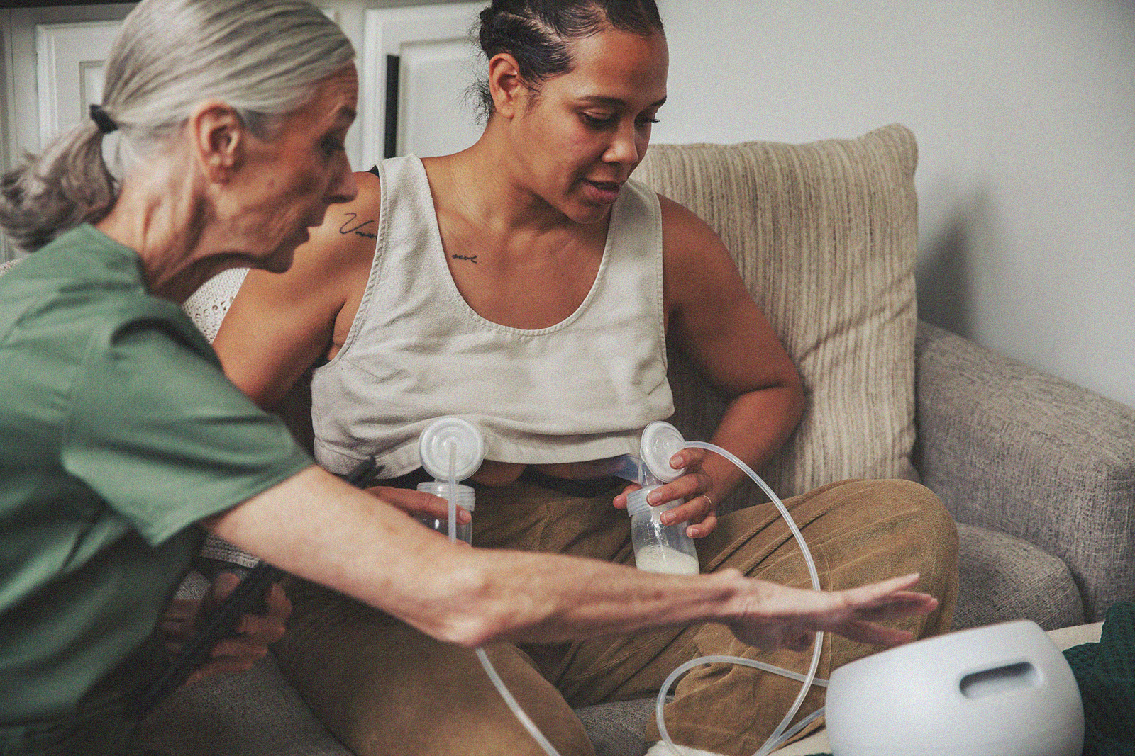 A parent using a breast pump with assistance from an International Board Certified Lactation Consultant, both focused and engaged in the process.