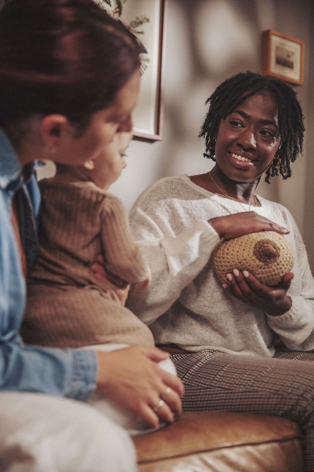 A parent holds their baby while an International Board Certified Lactation Consultant demonstrates breastfeeding techniques.