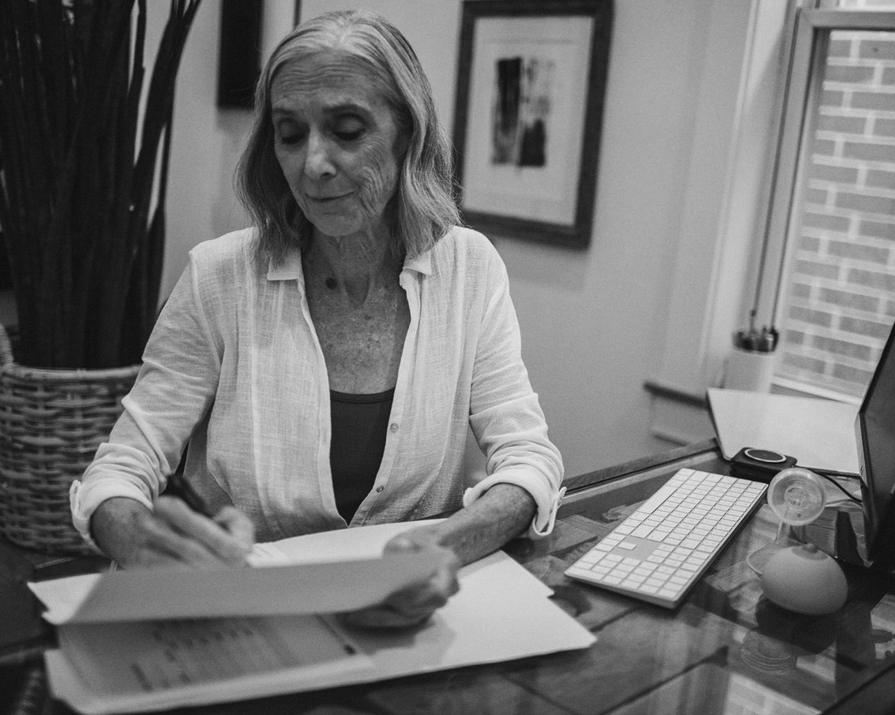 A professional working at a desk, reviewing documents with focus.