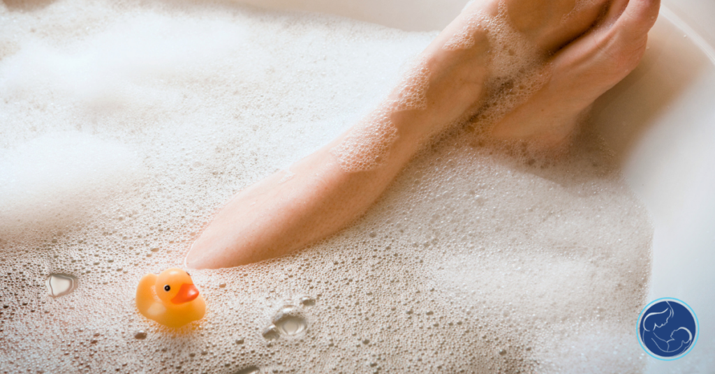 A parent takes a bubble bath as a rubber duck floats on the surface of the water in the tub