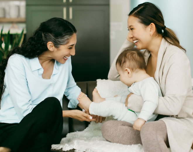 A parent and baby enjoying a playful moment during a lactation consultation session.