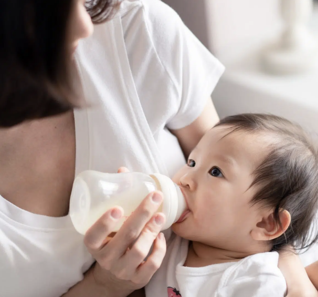 A parent feeding their baby from a bottle.