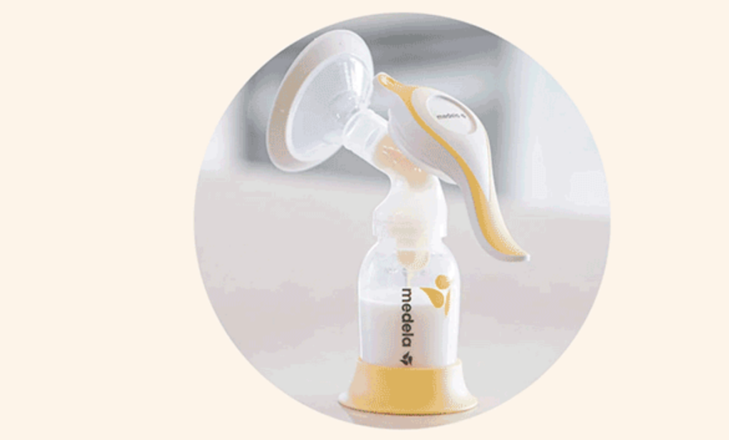 Medela manual breast pump filled with milk.