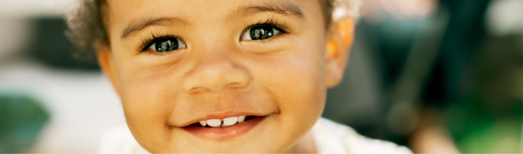 A close-up of a toddler with a bright and joyful expression.