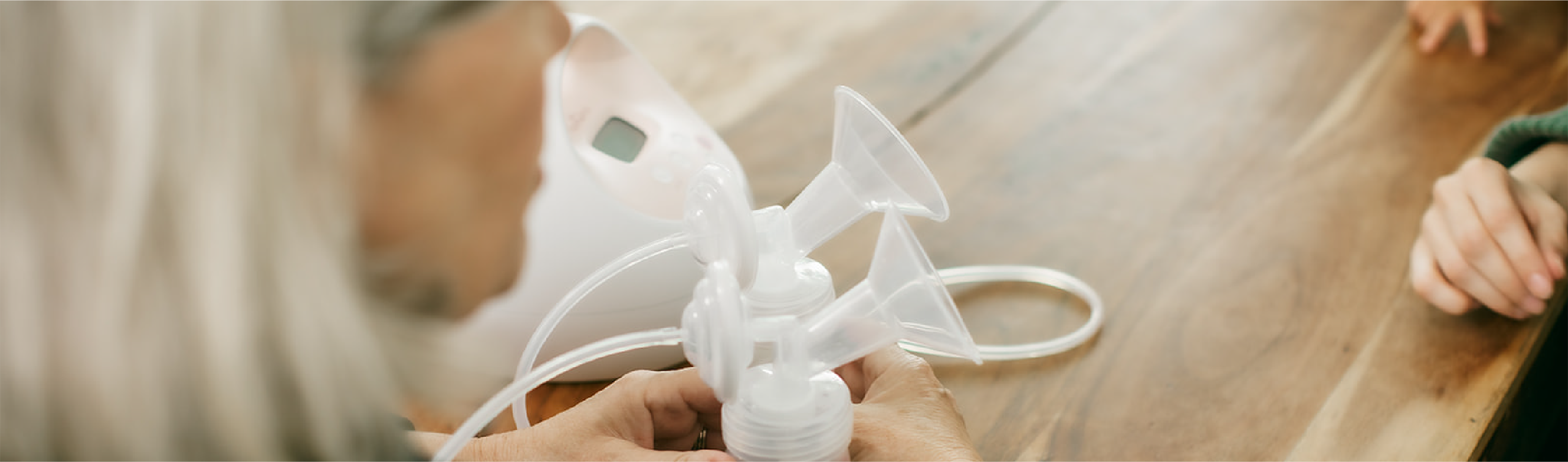 An International Board Certified Lactation Consultant prepares a breast pump for a parent during an in-person consultation.